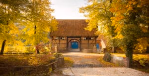 Firmeneventlocation 19 Backsteinscheune mit rotem Ziegeldach und blauen Türen – ein idealer Hochzeitsort für eine Freie Trauung in Münster Umgebung.