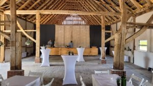 Firmeneventlocation 25 Rustikale Hochzeitslocation in Münster mit Holzbalken, Stehtischen und einer Holzbar.